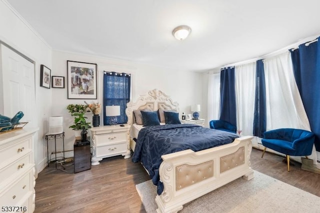 bedroom with crown molding and dark hardwood / wood-style flooring