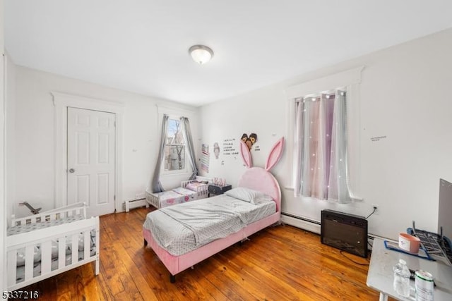 bedroom with hardwood / wood-style flooring and a baseboard radiator