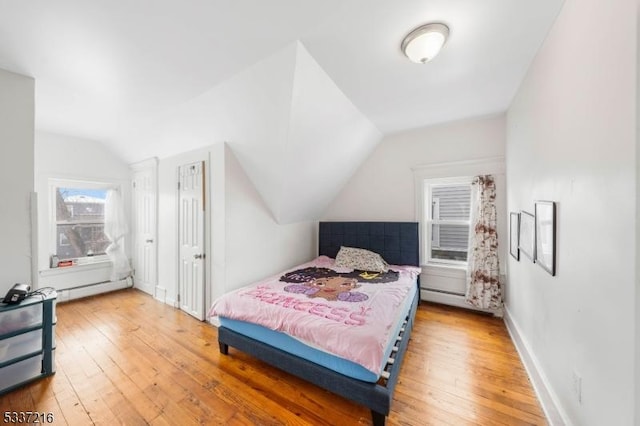 bedroom featuring lofted ceiling, hardwood / wood-style floors, and baseboard heating