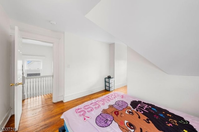 bedroom with lofted ceiling and hardwood / wood-style flooring