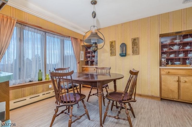 dining area with light wood-type flooring and baseboard heating