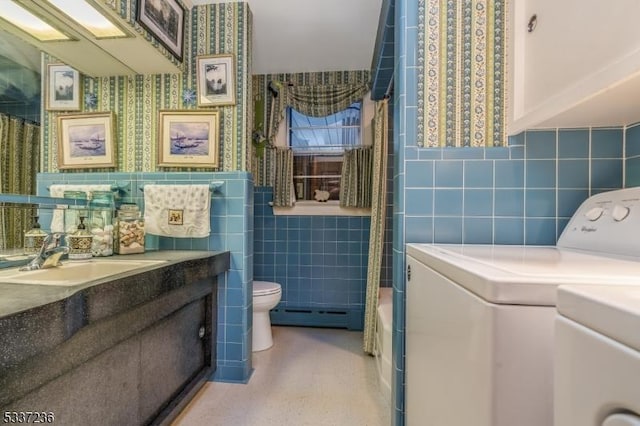 full bathroom featuring tile walls, a baseboard heating unit, vanity, toilet, and shower / bath combo with shower curtain