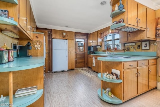 kitchen featuring white refrigerator, crown molding, sink, and light hardwood / wood-style floors