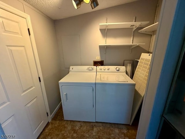 washroom with washing machine and clothes dryer and a textured ceiling