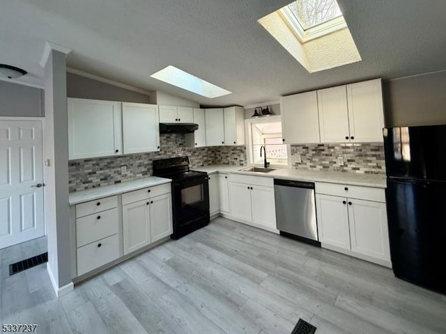 kitchen featuring white cabinetry, lofted ceiling, sink, and black appliances