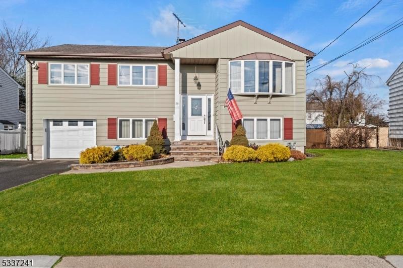 bi-level home featuring a garage and a front lawn