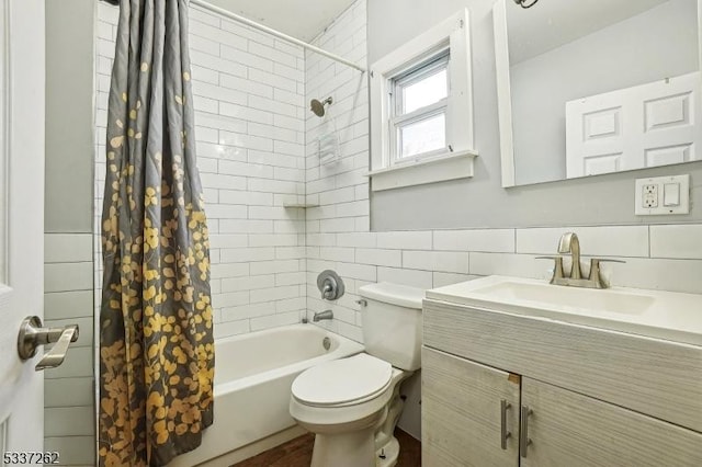 full bathroom with tile walls, shower / tub combo, vanity, and toilet