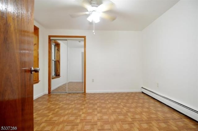 spare room with ceiling fan, a baseboard radiator, and light parquet flooring