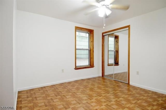 unfurnished room with ceiling fan and light parquet floors