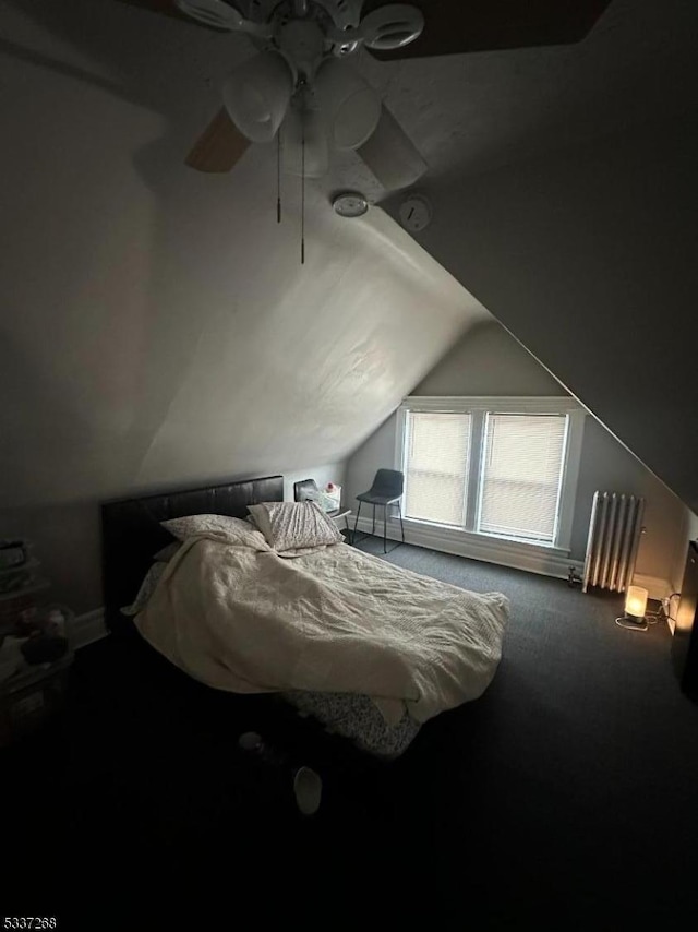 carpeted bedroom featuring radiator heating unit and vaulted ceiling