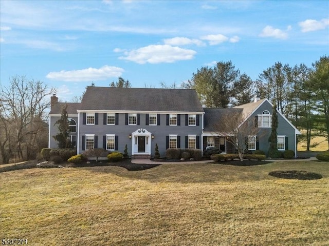 colonial-style house featuring a front yard