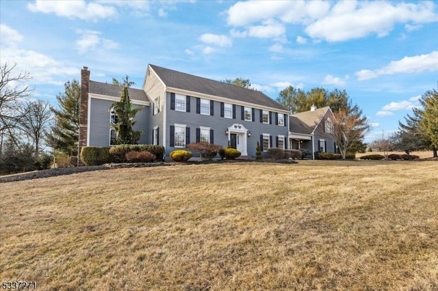 colonial house featuring a front lawn