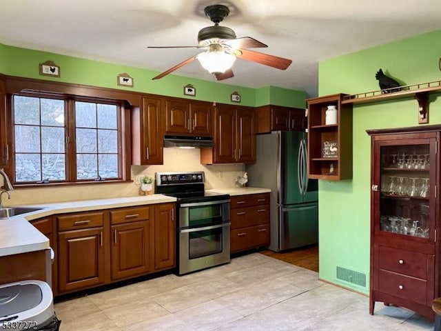 kitchen featuring under cabinet range hood, stainless steel appliances, a sink, visible vents, and light countertops