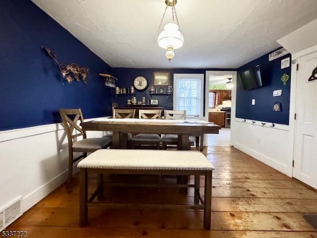 dining space featuring hardwood / wood-style flooring, baseboards, and visible vents