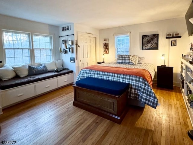 bedroom with multiple windows and light wood finished floors