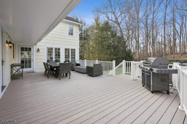 wooden terrace featuring a grill and an outdoor hangout area