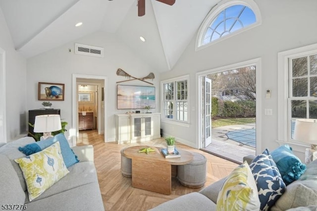 living room with light parquet flooring, a wealth of natural light, and high vaulted ceiling