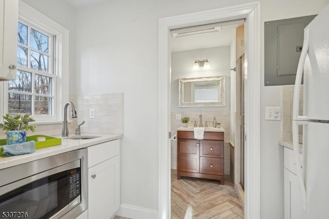 bathroom with parquet floors, vanity, and backsplash