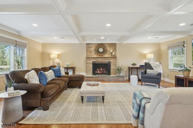 living room featuring a healthy amount of sunlight, coffered ceiling, and light wood-type flooring