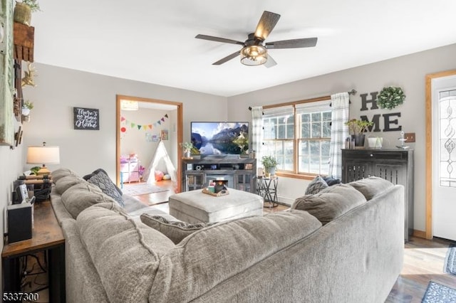 living room with ceiling fan and light hardwood / wood-style flooring