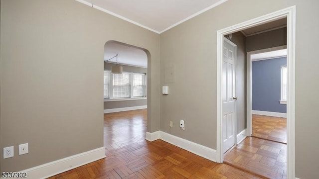 corridor featuring arched walkways, ornamental molding, and baseboards