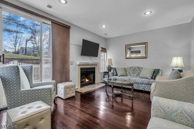 living room featuring a high end fireplace and dark hardwood / wood-style floors