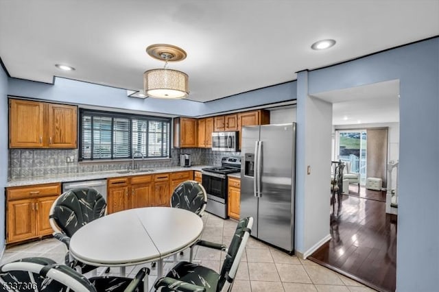 kitchen featuring tasteful backsplash, sink, light tile patterned floors, and appliances with stainless steel finishes