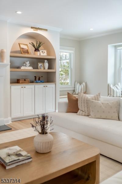 living room featuring ornamental molding and light hardwood / wood-style floors