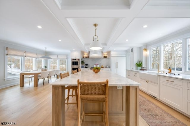 kitchen featuring hanging light fixtures, white cabinetry, and a large island