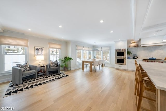 interior space featuring white cabinetry, light hardwood / wood-style flooring, plenty of natural light, pendant lighting, and stainless steel double oven