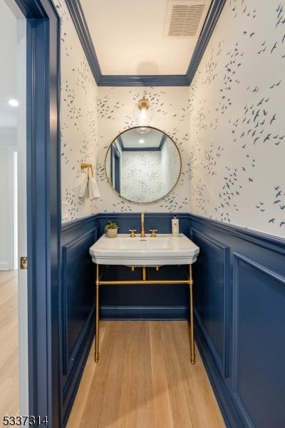 bathroom featuring crown molding, vanity, and wood-type flooring