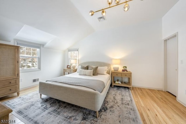 bedroom with vaulted ceiling and hardwood / wood-style floors