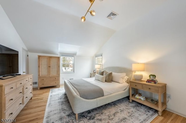 bedroom with lofted ceiling and light hardwood / wood-style flooring