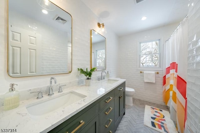 bathroom featuring tile walls, vanity, and toilet