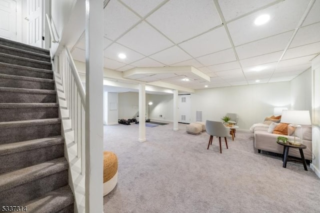 living room featuring a paneled ceiling and carpet