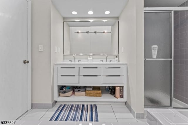 bathroom featuring tile patterned flooring, vanity, and a shower with shower door