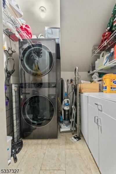 washroom with stacked washing maching and dryer