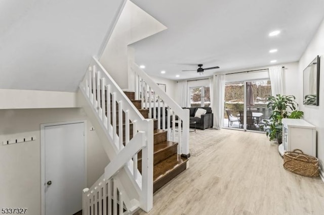 stairs with ceiling fan and hardwood / wood-style floors