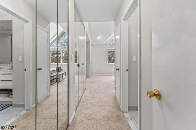 hall featuring light colored carpet and a healthy amount of sunlight