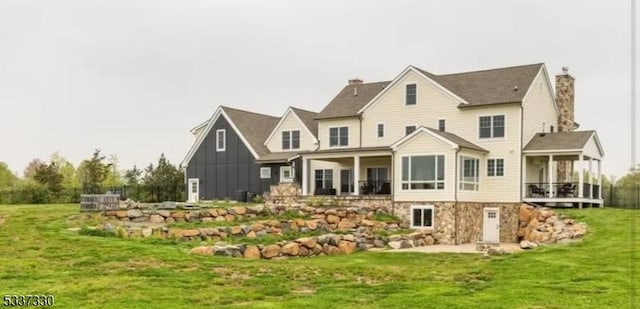 rear view of house featuring a yard