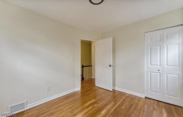 unfurnished bedroom featuring a closet and hardwood / wood-style floors