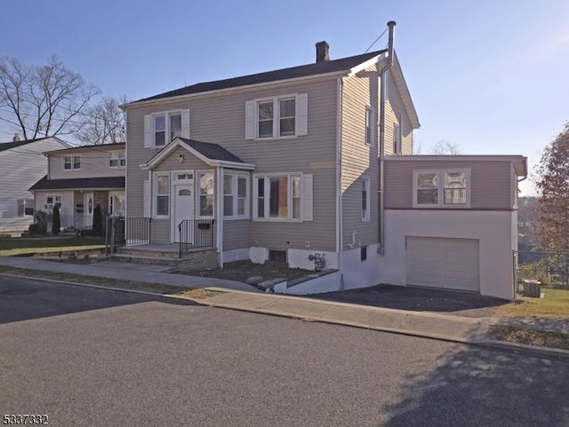 view of front of property with central AC unit and a garage