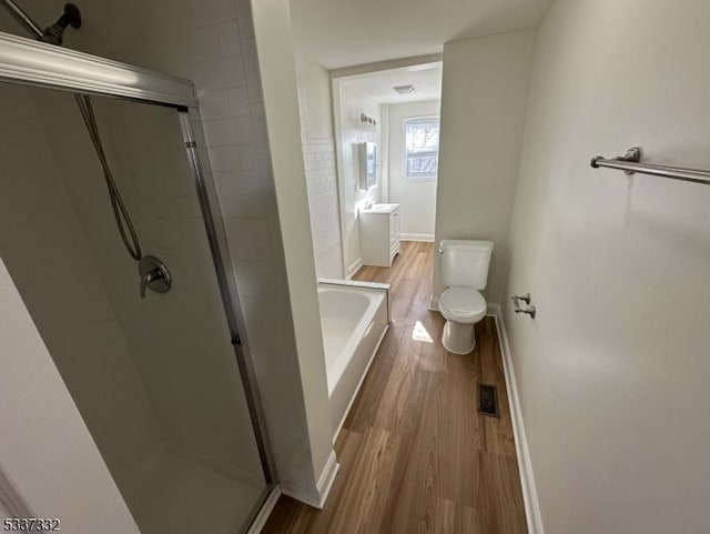 full bathroom with vanity, hardwood / wood-style flooring, plus walk in shower, and toilet