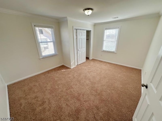 unfurnished bedroom featuring a closet, ornamental molding, and light carpet