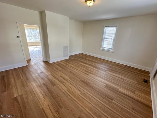 unfurnished room with hardwood / wood-style flooring