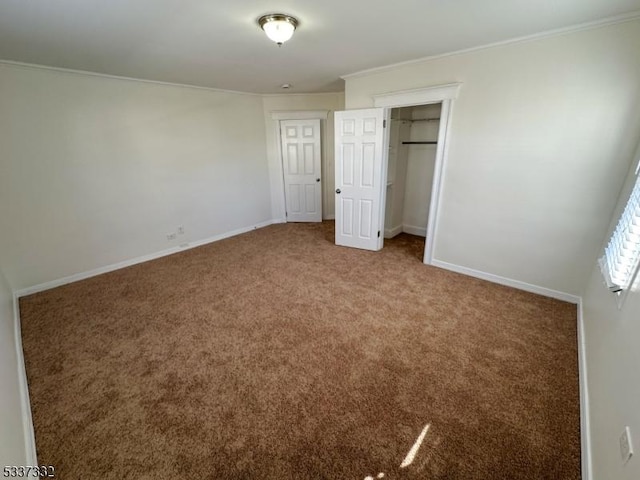 unfurnished bedroom featuring crown molding, carpet flooring, and a closet