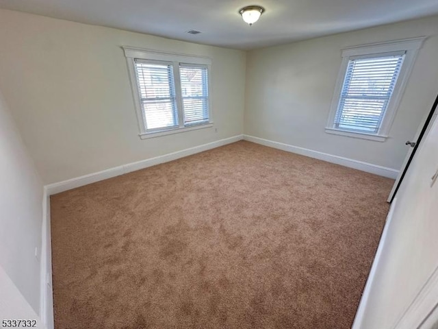 empty room with a wealth of natural light and light colored carpet