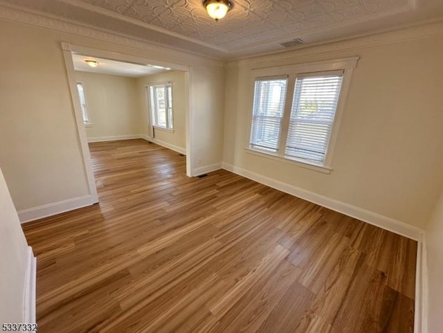 unfurnished room featuring ornamental molding and wood-type flooring