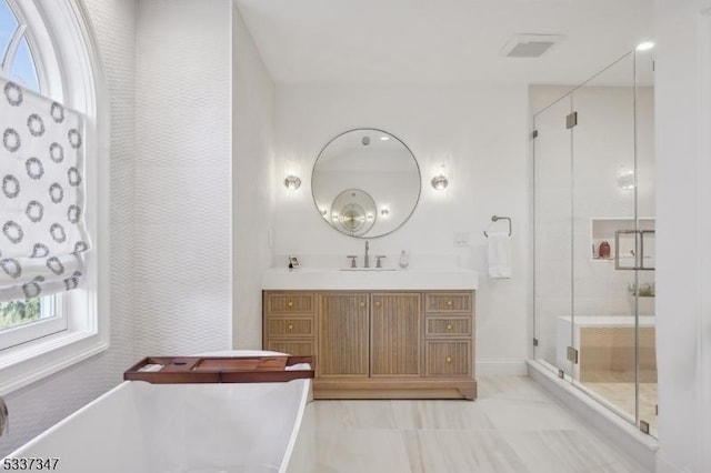 bathroom with a soaking tub, a shower stall, and a healthy amount of sunlight