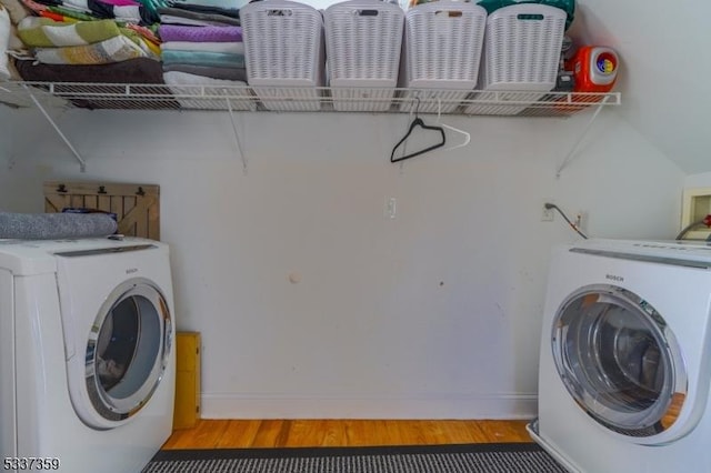 laundry room with laundry area, wood finished floors, and washer / dryer